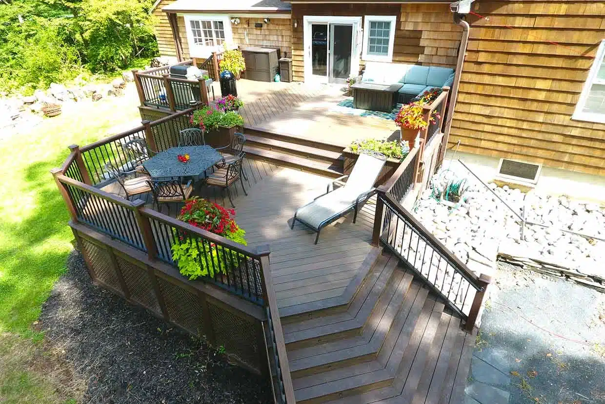 Multi-level custom composite deck with seating and planters in PA.